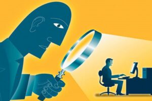 boss overseeing employee with magnifying glass